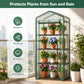 A freestanding mini greenhouse with a transparent green frame and black wire shelves, shown holding multiple potted flowers and plants. The scene is set on a balcony with a city skyline in the background, and a vertical feature callout on the left lists birdproof, windproof, waterproof, and UV protection benefits.